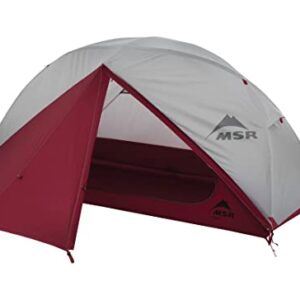 MSR Elixir 1-Person Lightweight Backpacking Tent set up in a scenic outdoor location, showcasing its unique pole geometry for extra headroom, versatile rainfly for stargazing, and freestanding design with color-coded setup system