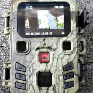 Compact hunting trail camera with 20MP resolution and night vision, mounted outdoors for wildlife monitoring and security.